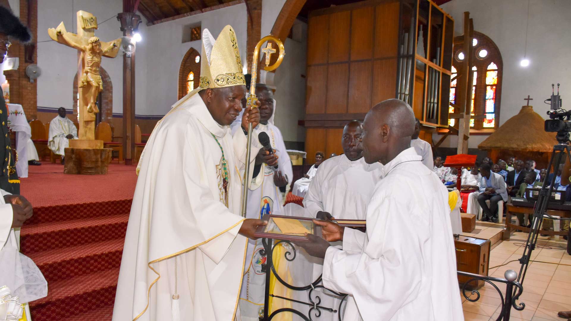 Musomesa Matovu Lawrence receiving certficate from the Bishop