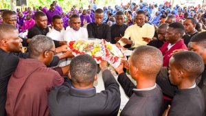 Fellow seminarians laying a bouquete of flowers on casket